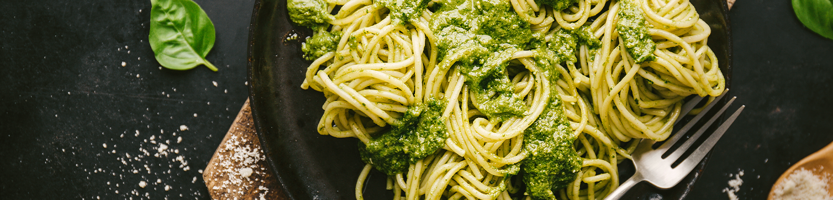 Pasta mit grüner Pesto auf schwarzem Teller