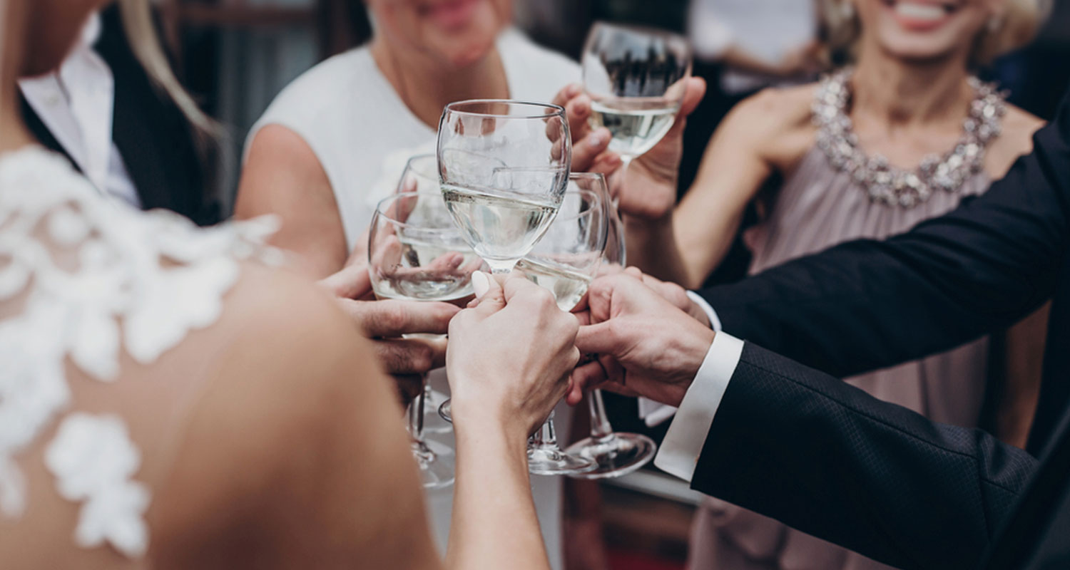 Auf einer Hochzeit stoßen Freunde mit Wein an. 