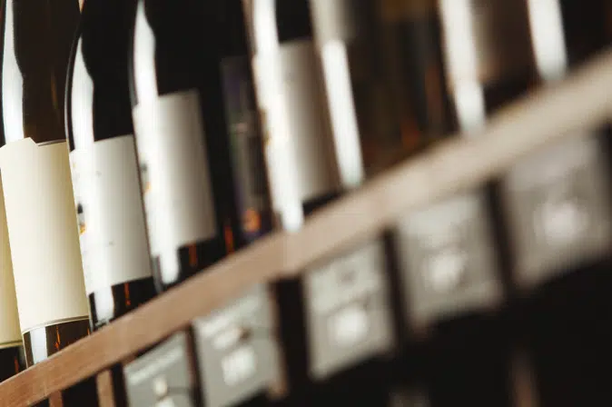 Rotweinflaschen aufgereiht in Regal