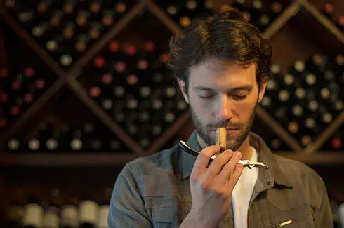 Mann riecht an Korken